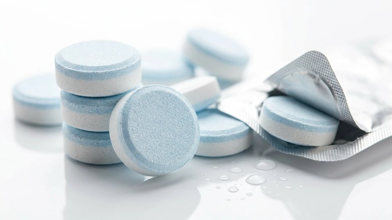 Pressed white and blue cleaning tablets with foil pack Pressed white and blue cleaning tablets with foil pack